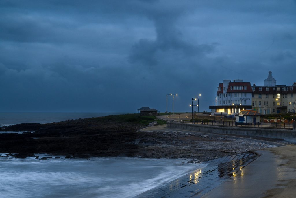 Rain clouds gather over a seaside town.