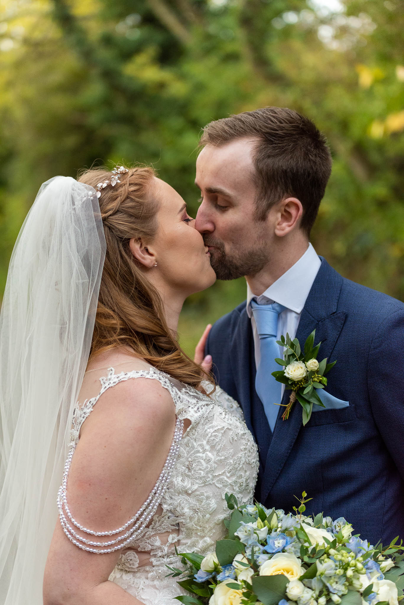Newlywed couple sharing an intimate, unscripted kiss during a wedding reception in Sutton Coldfield, captured by alternative photographer Charlie Hannah