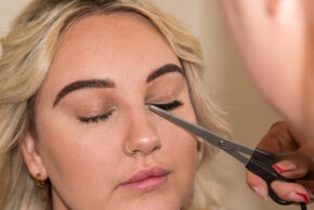 A close-up, candid documentary photo of a wedding morning prep moment with beauty grooming in South Wales.