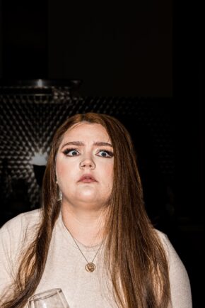 A candid, unscripted documentary photo of a shocked or panicked bride with wide eyes during wedding morning preparations.