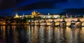 Charles Bridge, Prague - June 2017 The historic Charles Bridge and Prague Castle illuminated at night with golden lights reflecting on the Vltava River