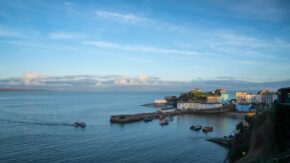 Tenby harbour and colourful coastal buildings under a bright blue sky in Pembrokeshire