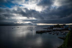 Tenby Harbour, a colourful coastal town under a dramatic long-exposure moody sky in Pembrokeshire