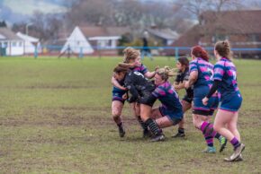 Llantwit Fardre Action sports photography of a fierce rugby tackle in progress on a muddy field, with players locked in competition during a live match.