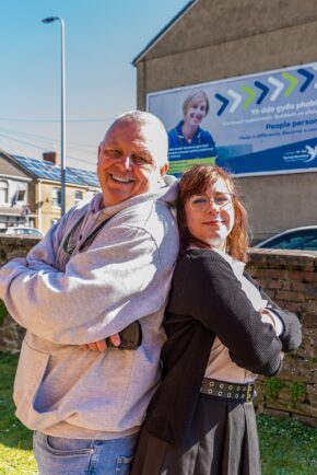 A fantastic, fun back-to-back outdoor portrait featuring yours truly and Šarlotė Iskenderova (Charlie) on location during the shoot. Outdoor back-to-back portrait of Charlie Hannah in a grey hoodie and Šarlotė Iskenderova (Charlie) with arms crossed, smiling outdoors.