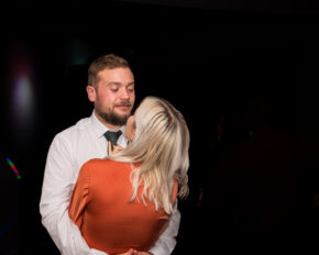 A close-up, unposed candid photograph of a couple deeply immersed in each other during the evening wedding reception, captured by Charlie Hannah.