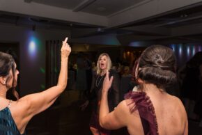 High-energy evening reception photography capturing a guest reacting playfully to the camera during the night time shenanigans at a wedding, captured by Charlie Hannah.