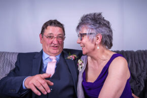 Relaxed candid portrait of wedding guests smiling and laughing at a reception in South Wales.