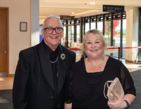 Roger Burnell MBE smiling alongside a guest at an indoor venue event, photographed by South Wales event photographer Charlie Hannah