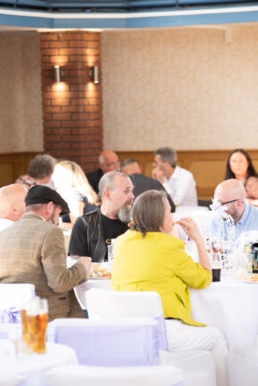 Candid shot of wedding guests enjoying food and conversation at tables during the wedding reception at Stourbridge Registry Office, photographed by Charlie Hannah