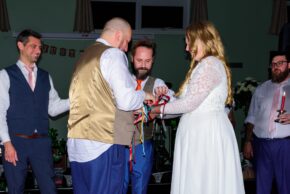 Bride and groom participating in a traditional handfasting ceremony ritual during their alternative wedding, photographed by Charlie Hannah