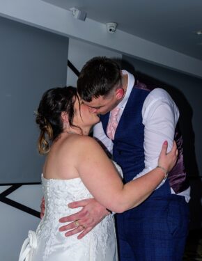 Bride and groom sharing a close embrace and kiss during their evening reception, photographed by South Wales wedding photographer Charlie Hannah