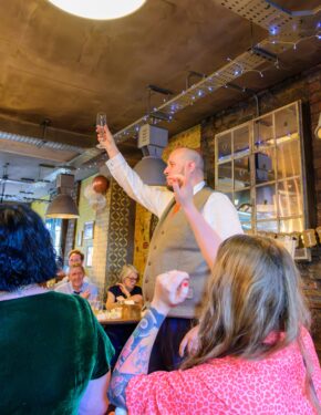 Groom raising a glass to make a toast during a wedding reception, photographed by South Wales wedding photographer Charlie Hannah